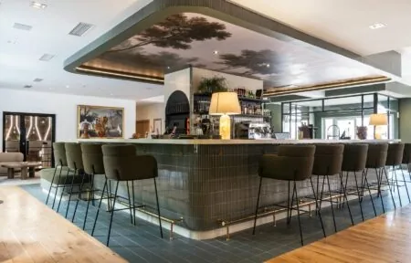 un bar avec une peinture d'arbres au plafond