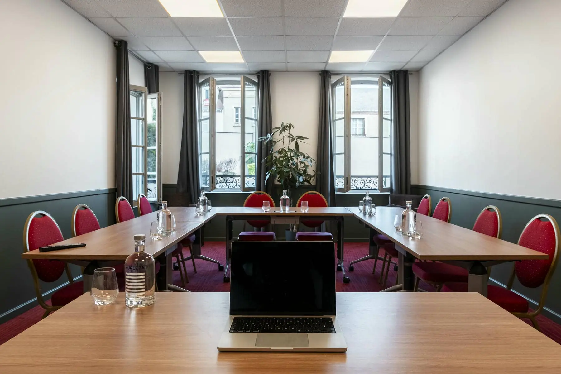 un ordinateur portable est posé sur une table dans une salle de conférence
