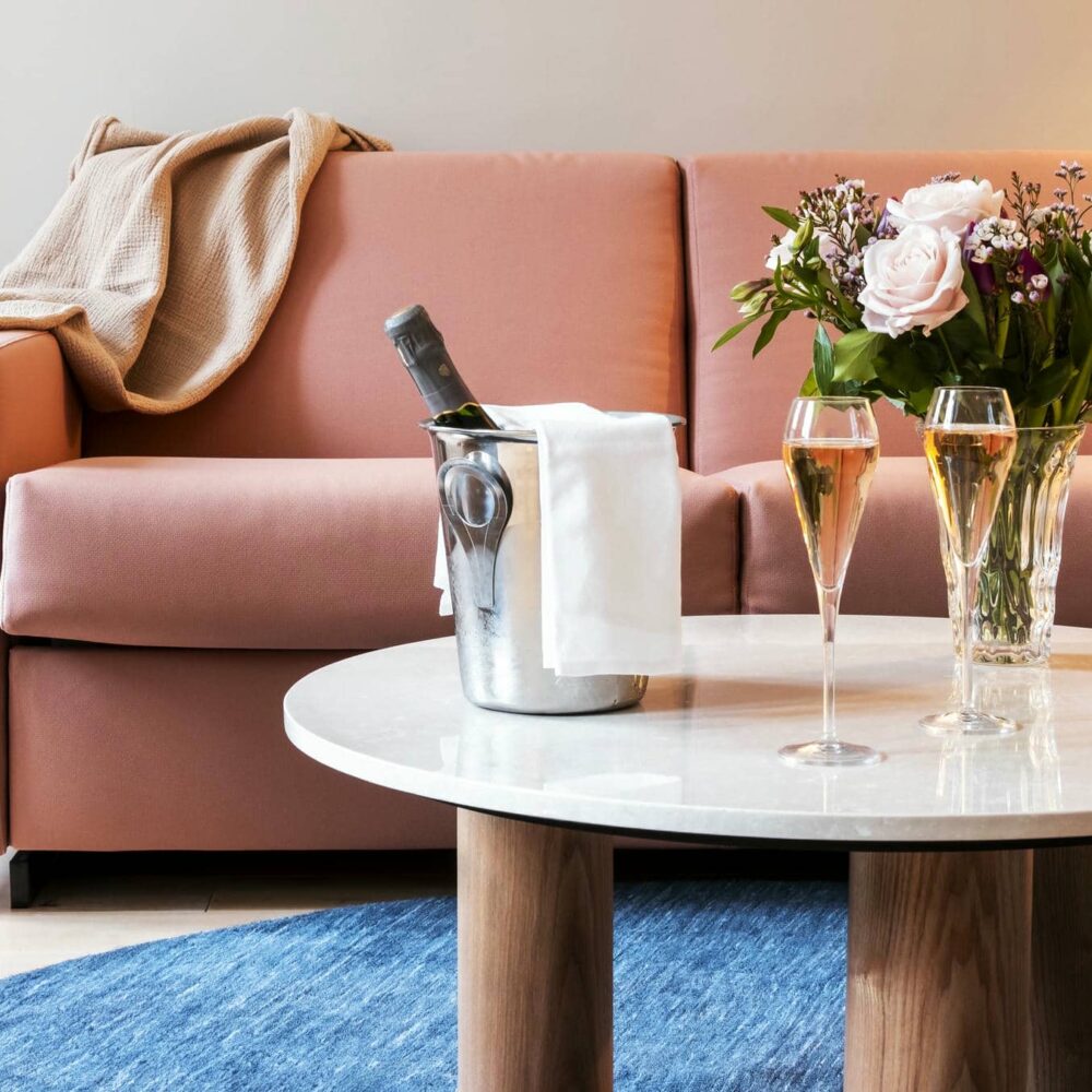 une table avec deux coupes de champagne et une bouteille de vin dans un seau