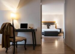 a desk with a laptop on it in a hotel room