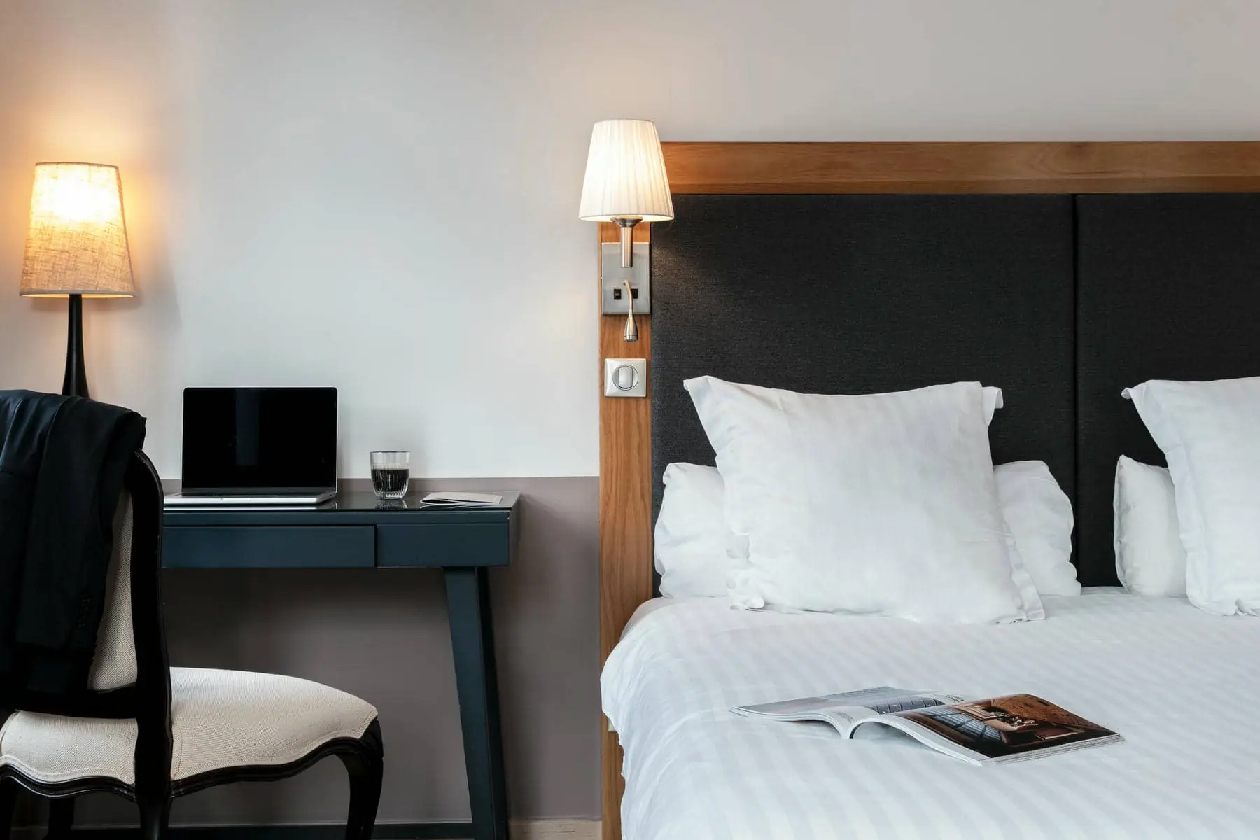 une chambre d'hôtel avec un lit, un bureau et une lampe