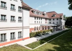 un grand bâtiment blanc avec une pelouse devant lui