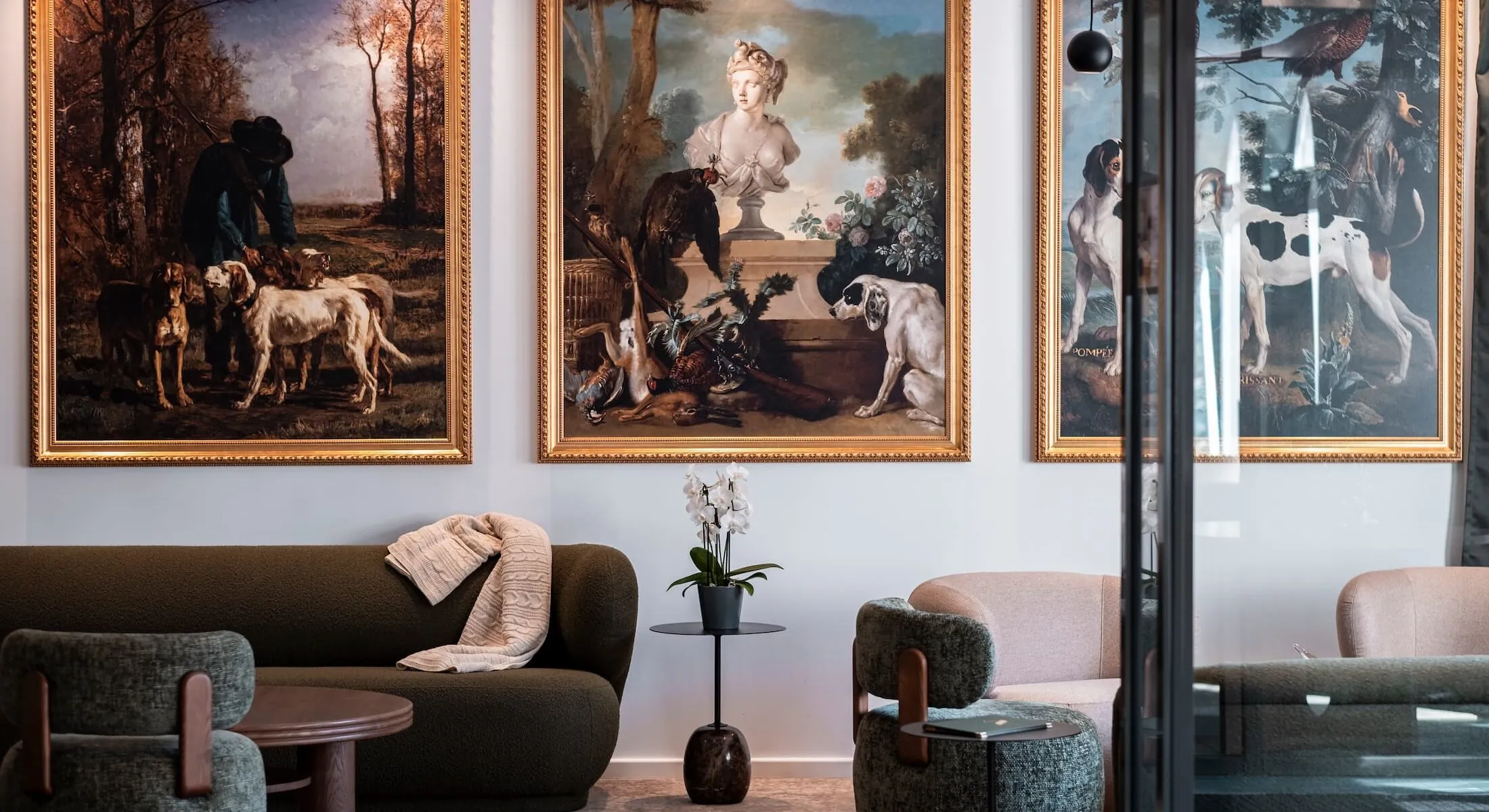 trois tableaux encadrés sont accrochés au mur au-dessus d'un canapé