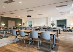 a large room with tables and chairs and a projector