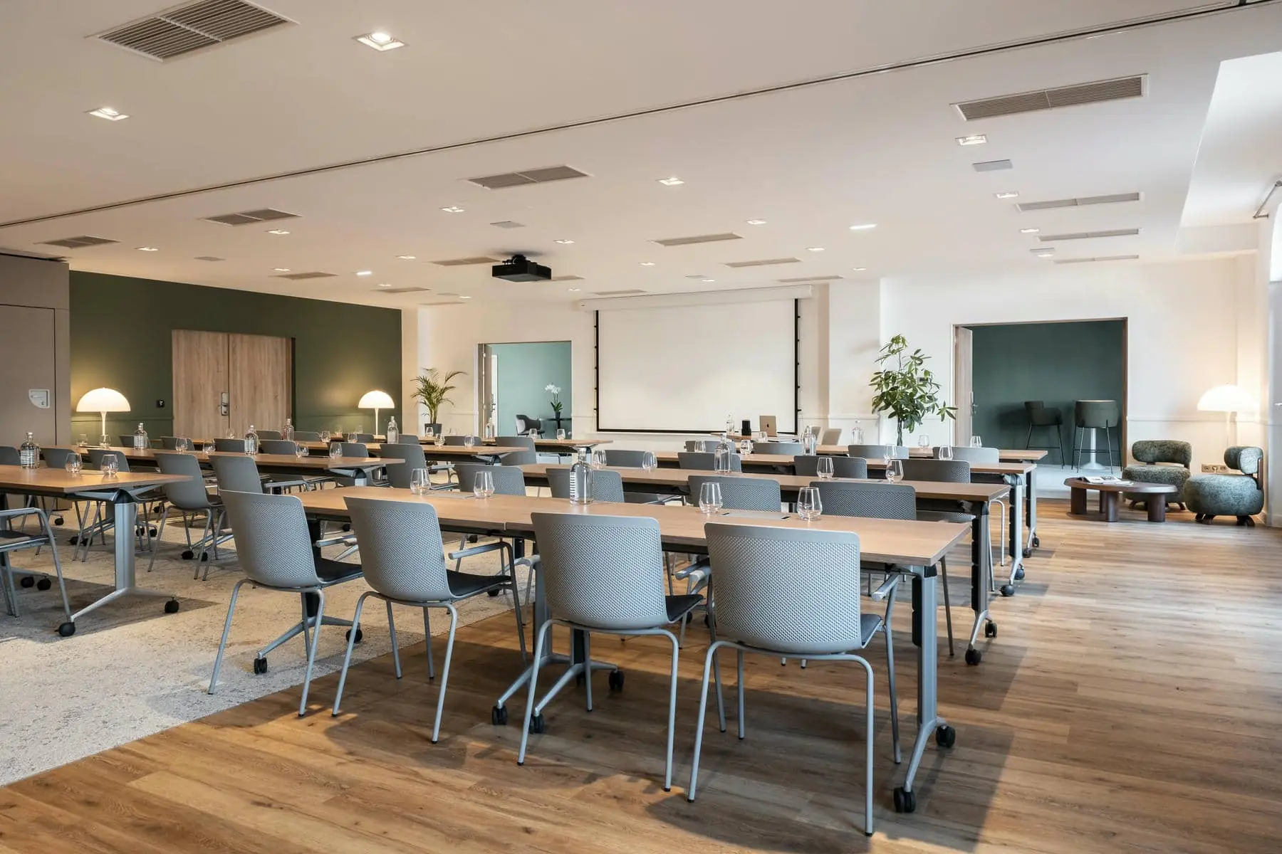 une grande salle avec des tables et des chaises et un projecteur