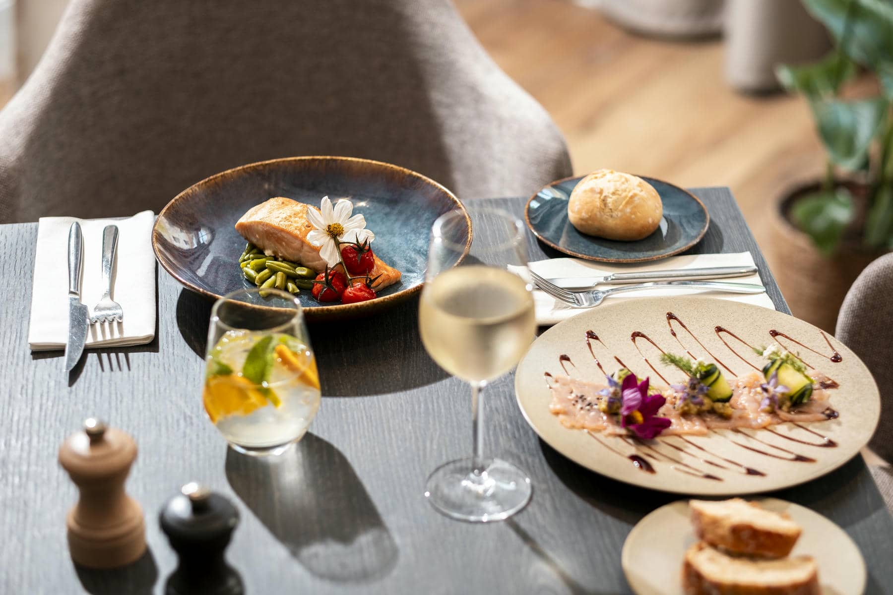 une table avec des assiettes de nourriture et un verre de vin