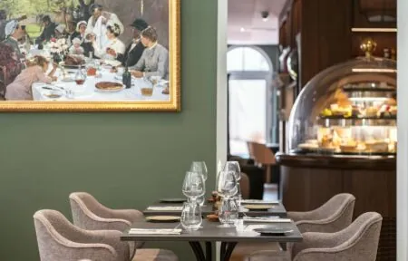 une peinture de personnes assises à une table dans un restaurant