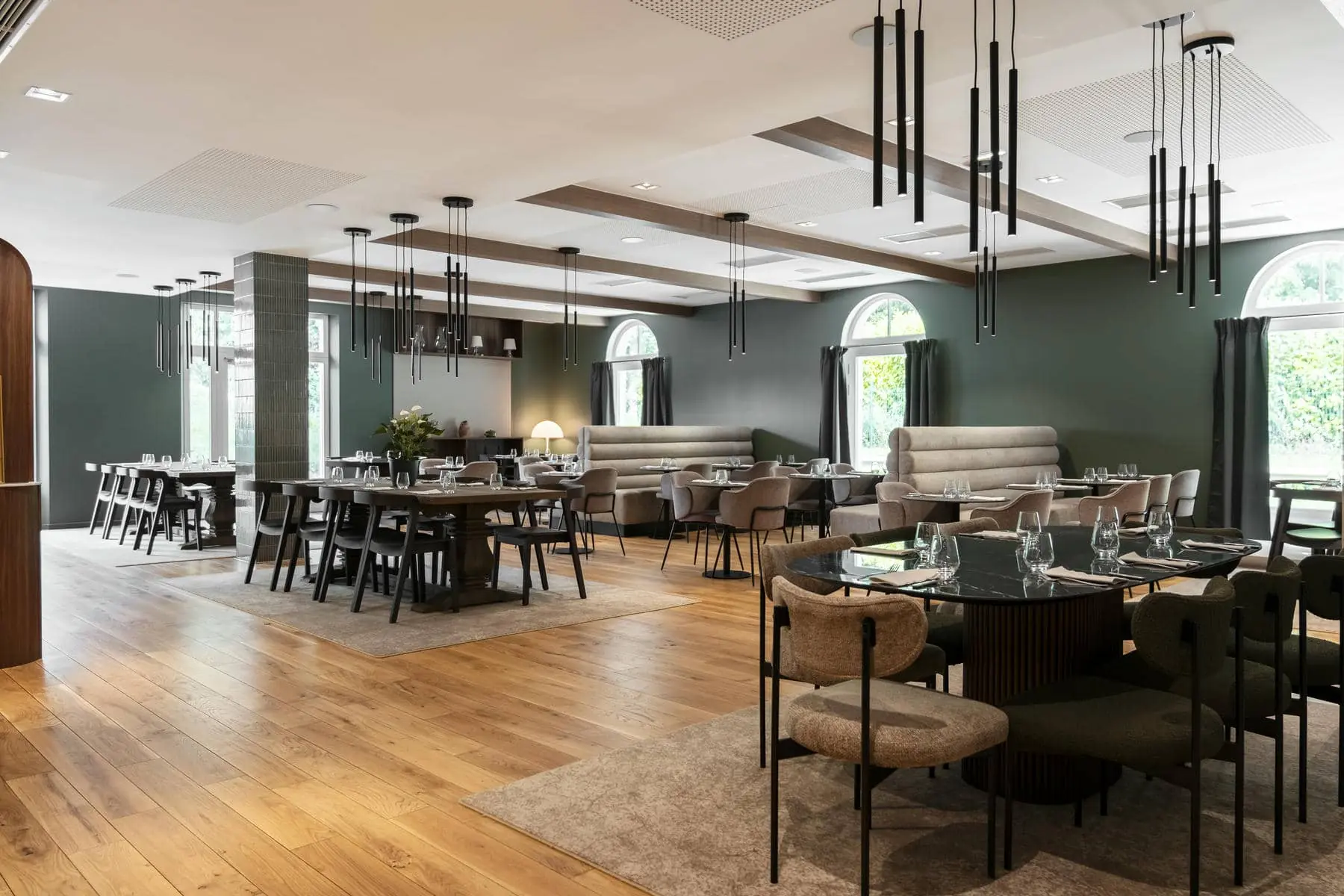 un restaurant avec des tables et des chaises et un mur vert