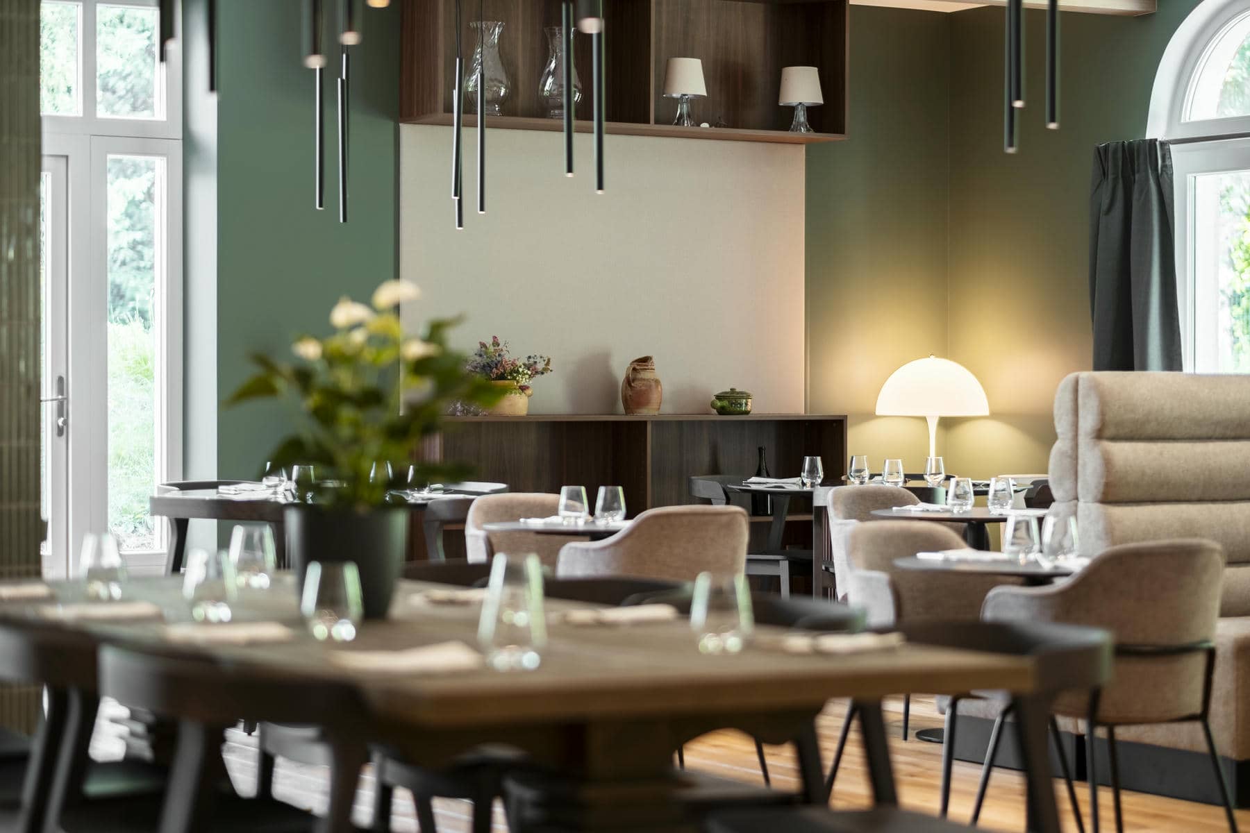 un restaurant avec des tables et des chaises et un vase de fleurs sur la table