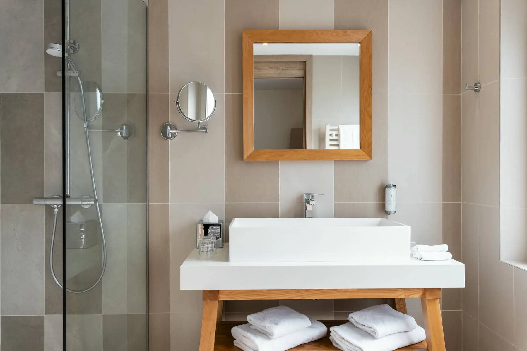 une salle de bain avec un lavabo, un miroir et une douche