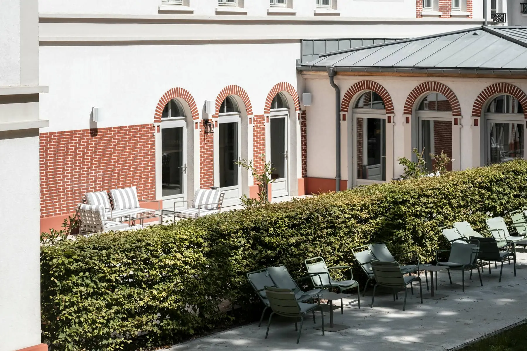 une rangée de chaises devant un bâtiment aux fenêtres cintrées