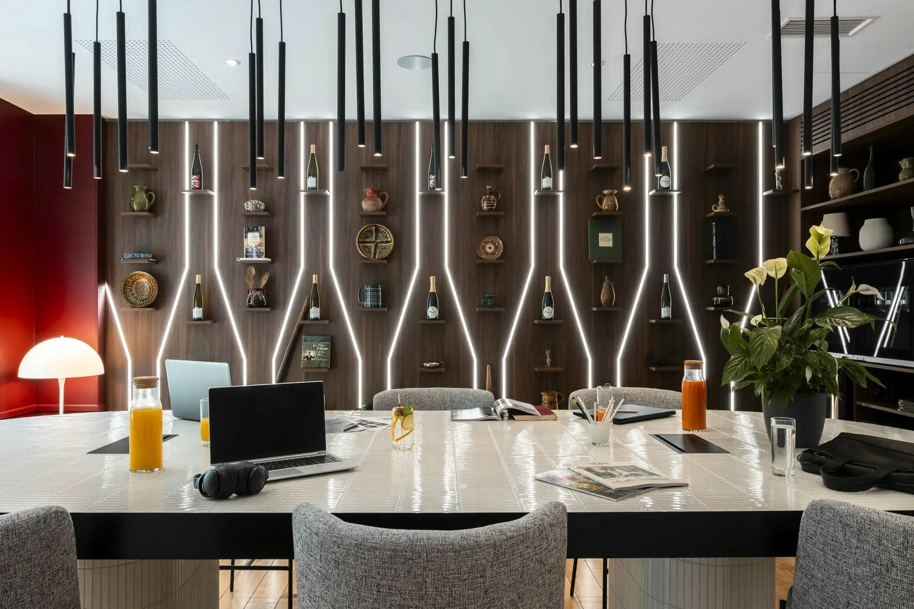 une table sur laquelle se trouve un ordinateur portable et une bouteille de jus d'orange