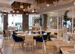 un restaurant avec des tables et des chaises et un tableau sur le mur