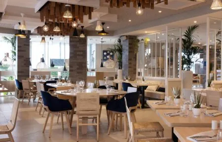 un restaurant avec des tables et des chaises et un tableau sur le mur