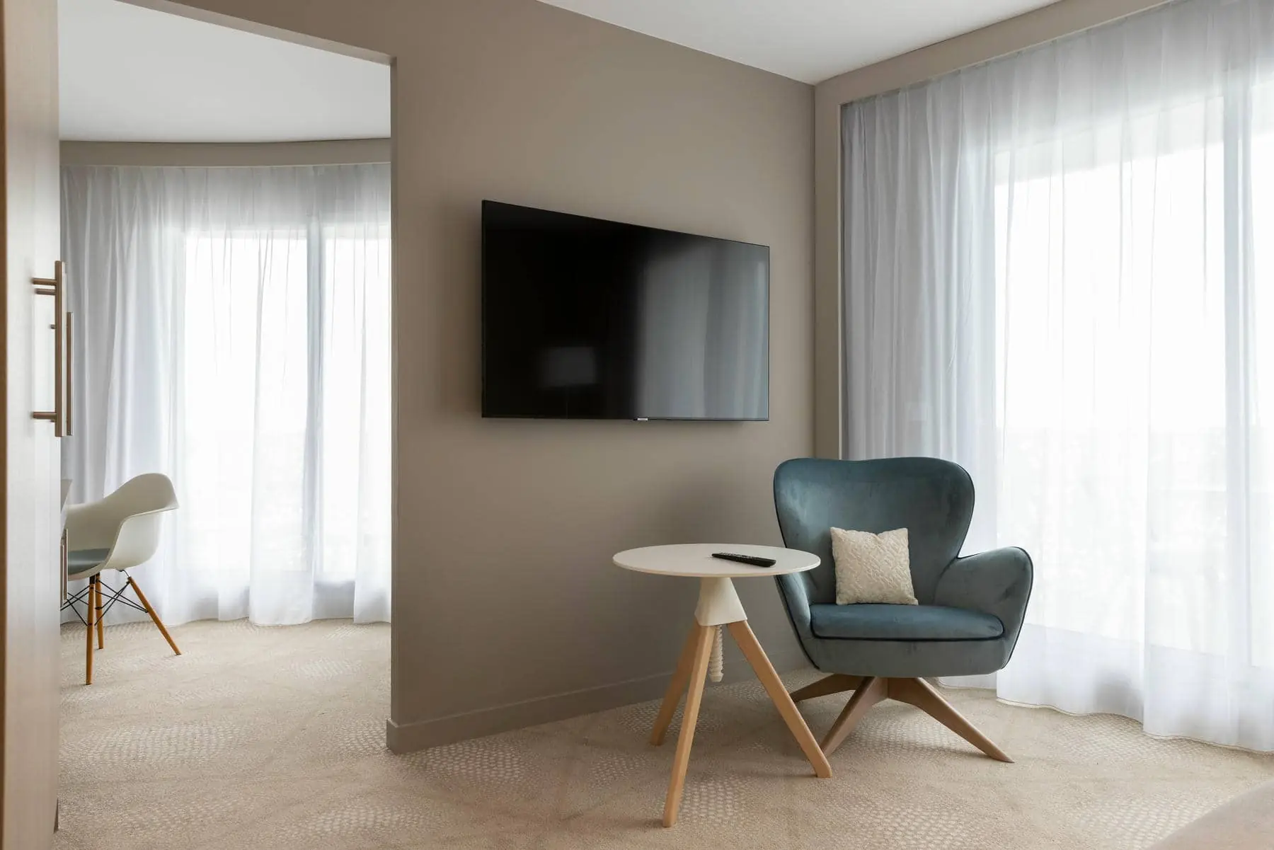 une pièce avec une chaise et une télévision au mur