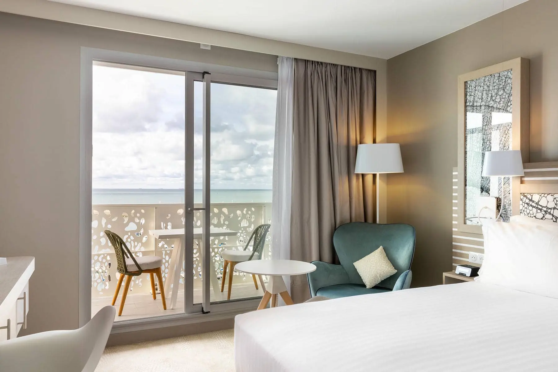 une chambre d'hôtel avec une porte coulissante en verre donnant sur un balcon