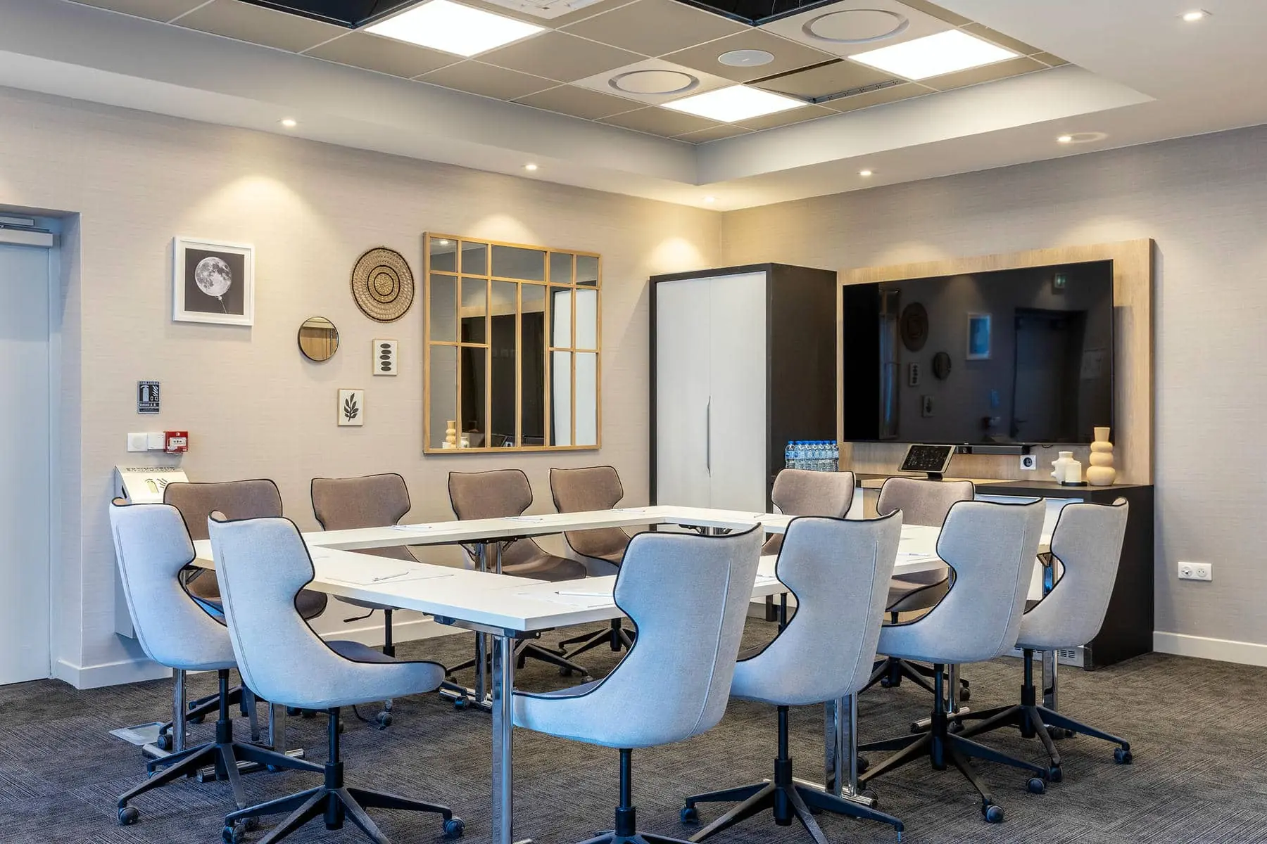 une salle de conférence avec des tables et des chaises et un extincteur au mur