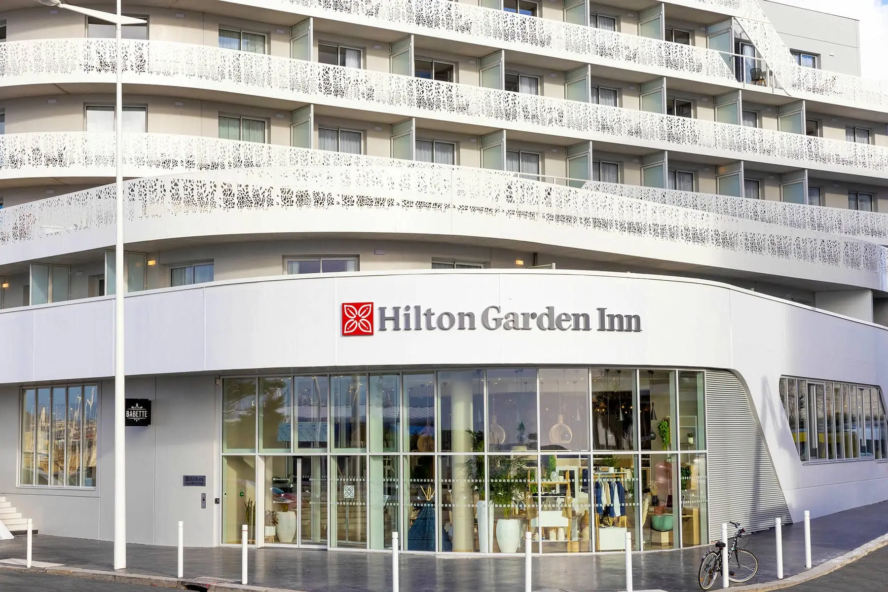 un bâtiment blanc avec un panneau indiquant hilton garden inn
