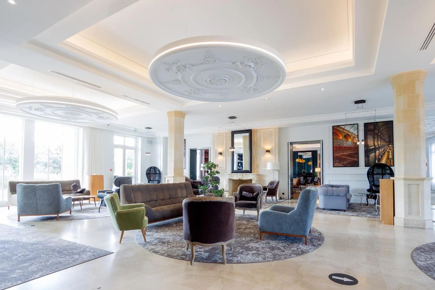 lobby de l’hôtel offrant une vue sur le domaine verdoyant, avec accès direct au bar