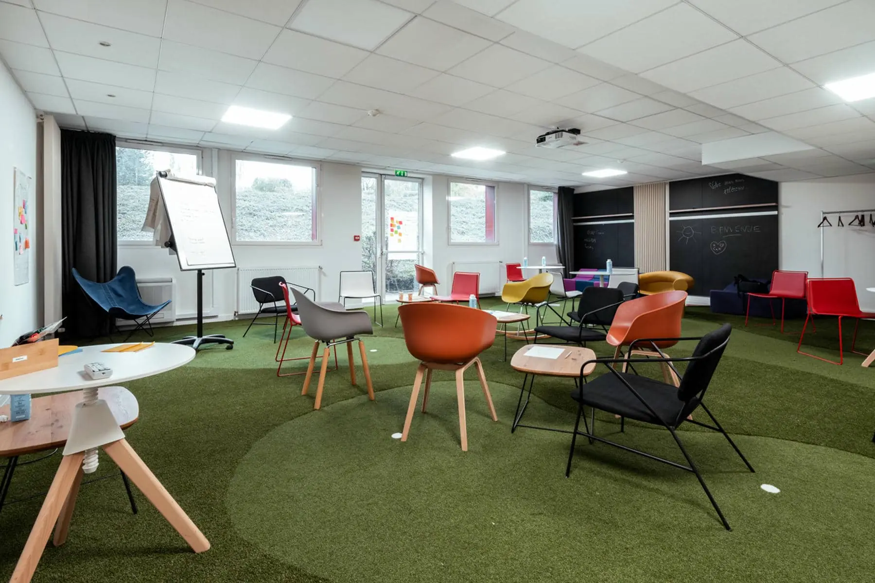 une salle avec des tables et des chaises et un tableau noir sur lequel est écrit "exploration"