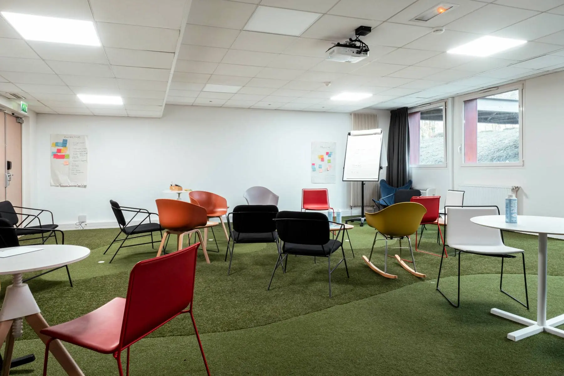 une salle avec des tables et des chaises et un projecteur au plafond