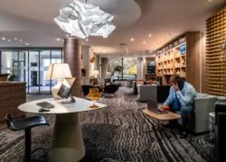 un homme est assis à une table avec un ordinateur et un verre de jus d'orange