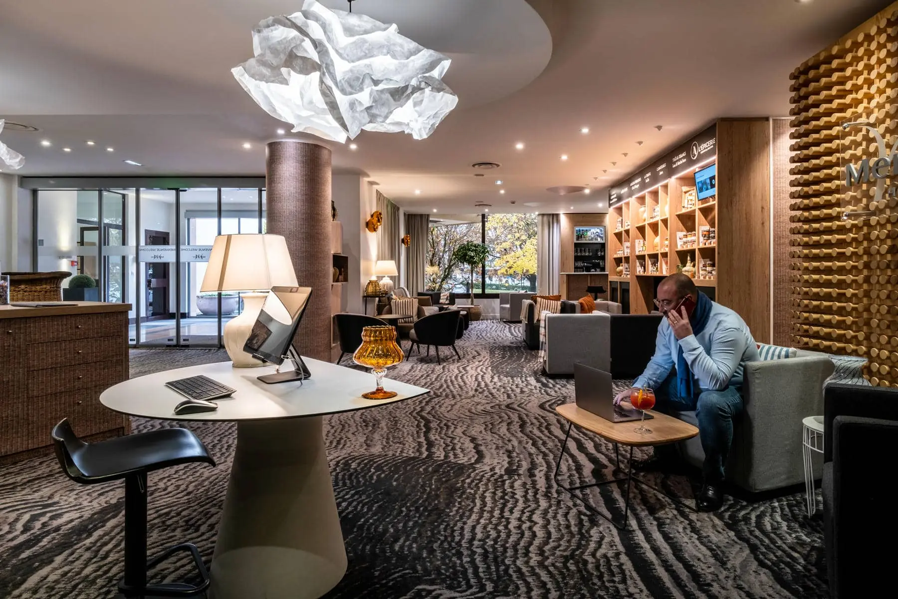 un homme est assis à une table avec un ordinateur et un verre de jus d'orange