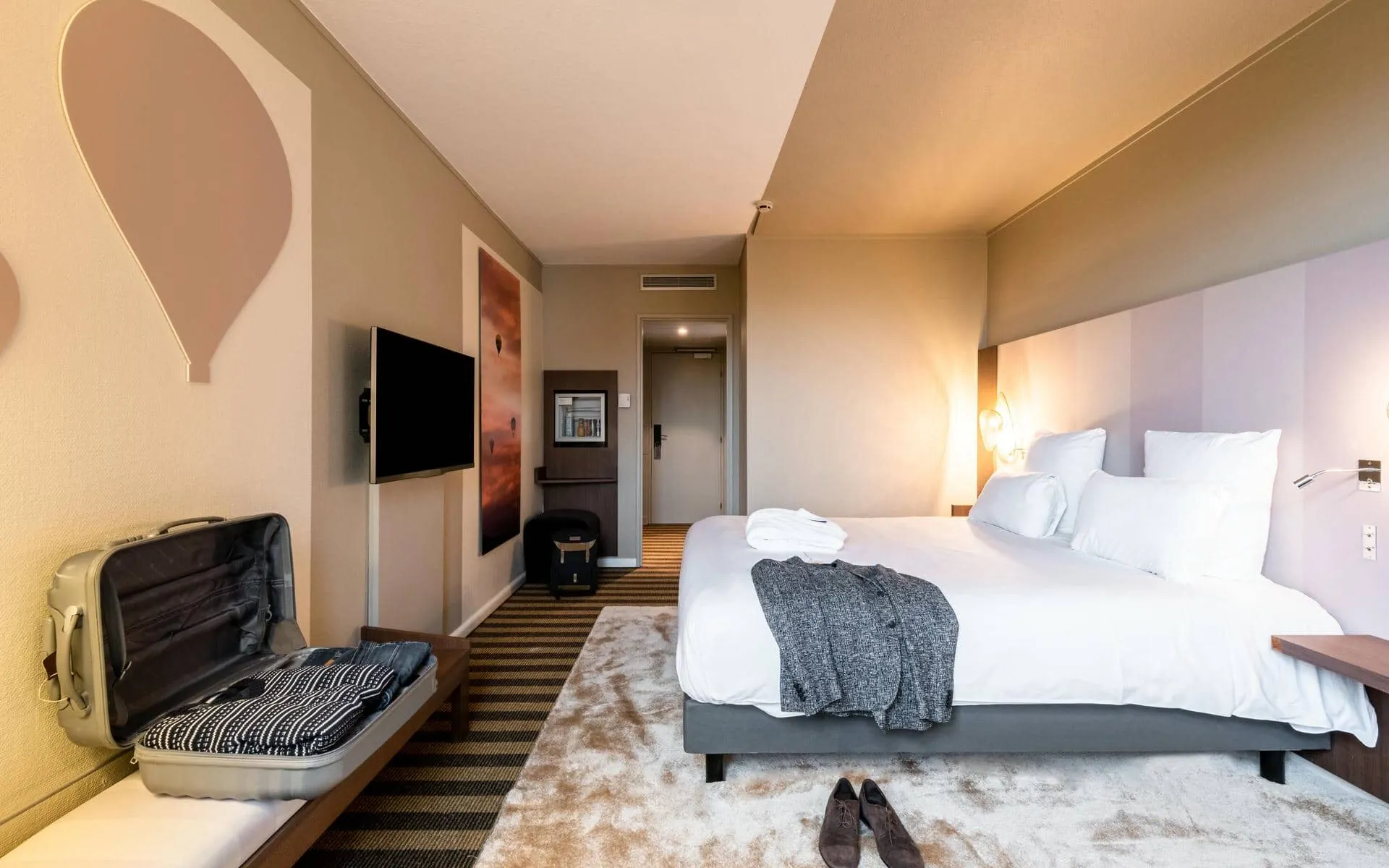 une chambre d'hôtel avec un lit et une valise