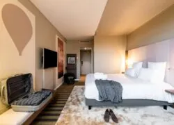 a hotel room with a bed and a suitcase