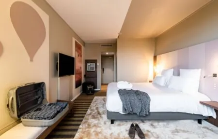 une chambre d'hôtel avec un lit et une valise