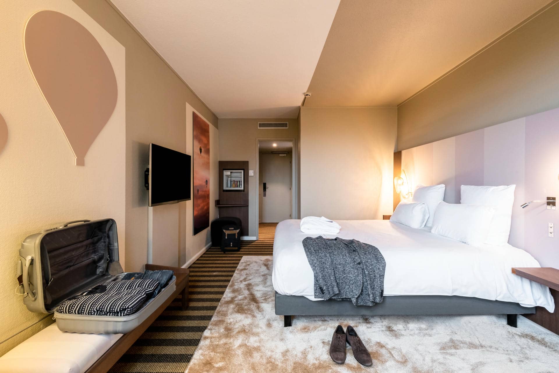 une chambre d'hôtel avec un lit et une valise