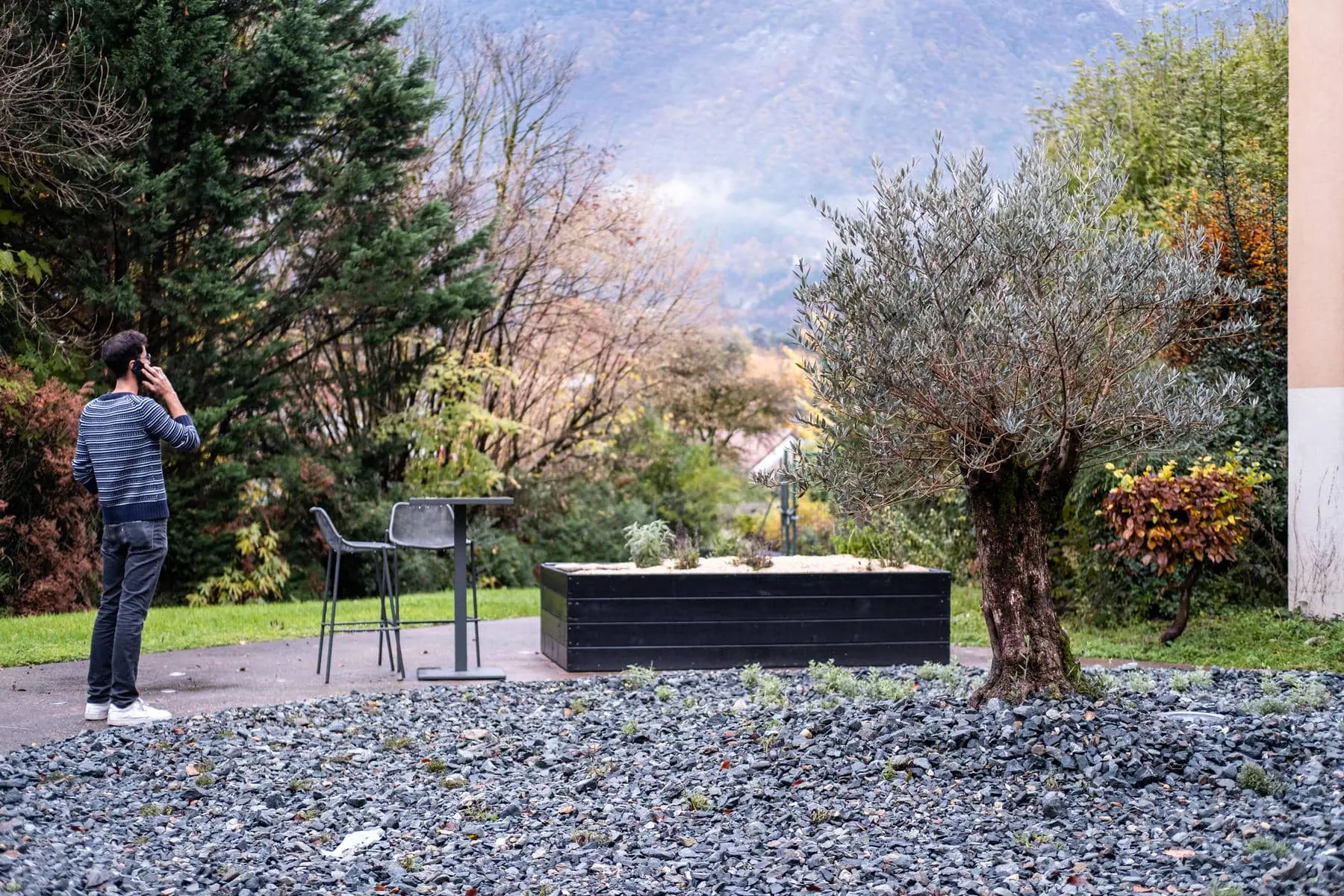 un homme parlant au téléphone portable dans un jardin