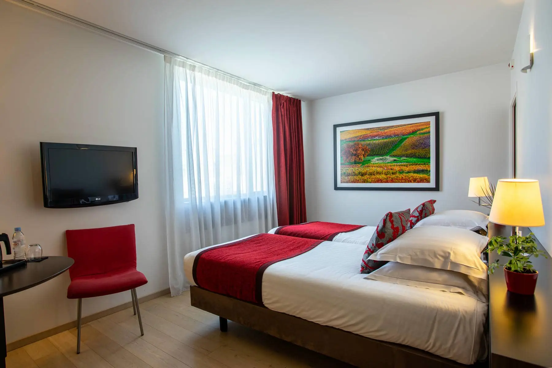 une chambre d'hôtel avec deux lits et un tableau au mur