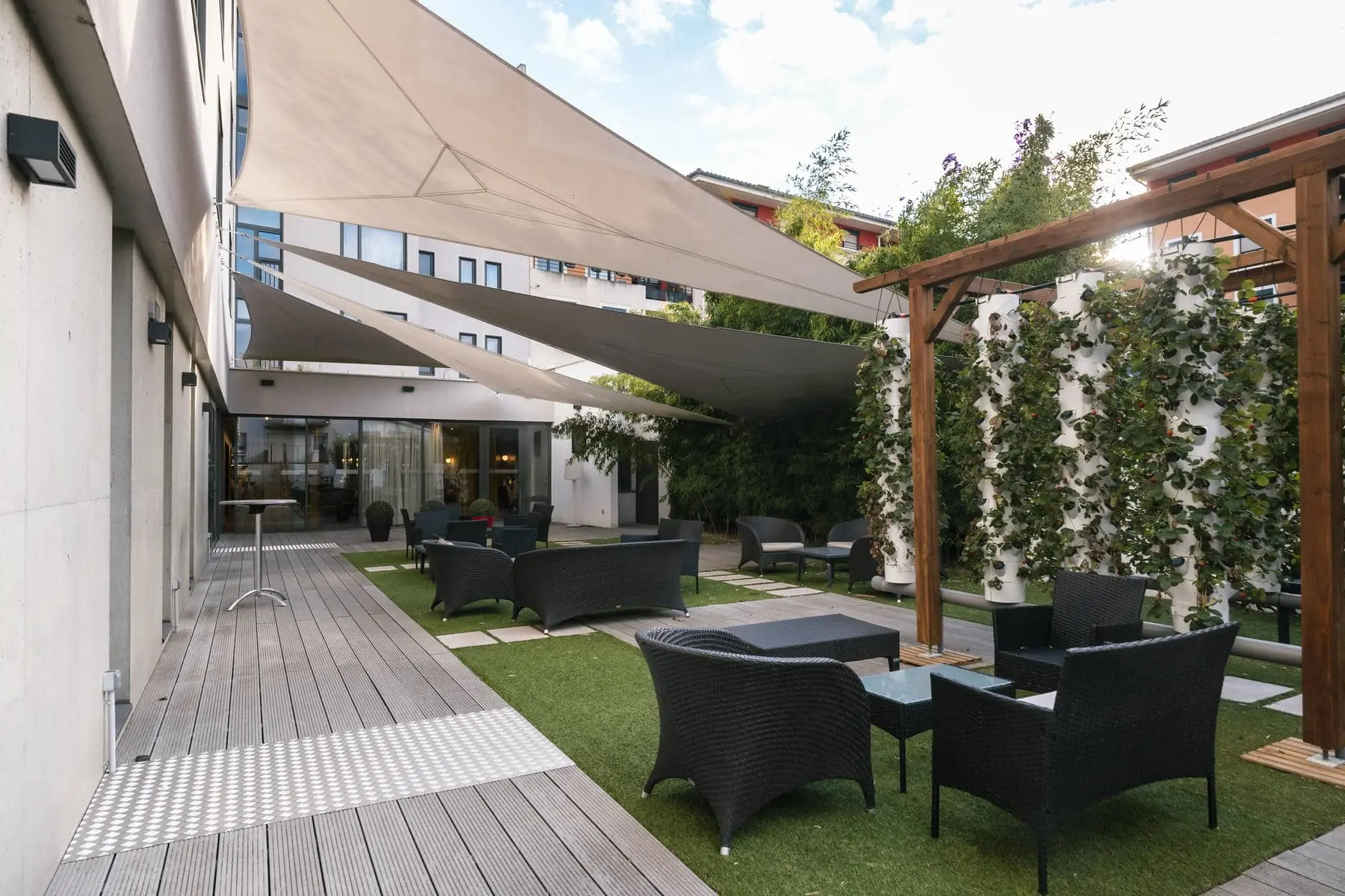 un patio avec des chaises et des tables sous des parasols