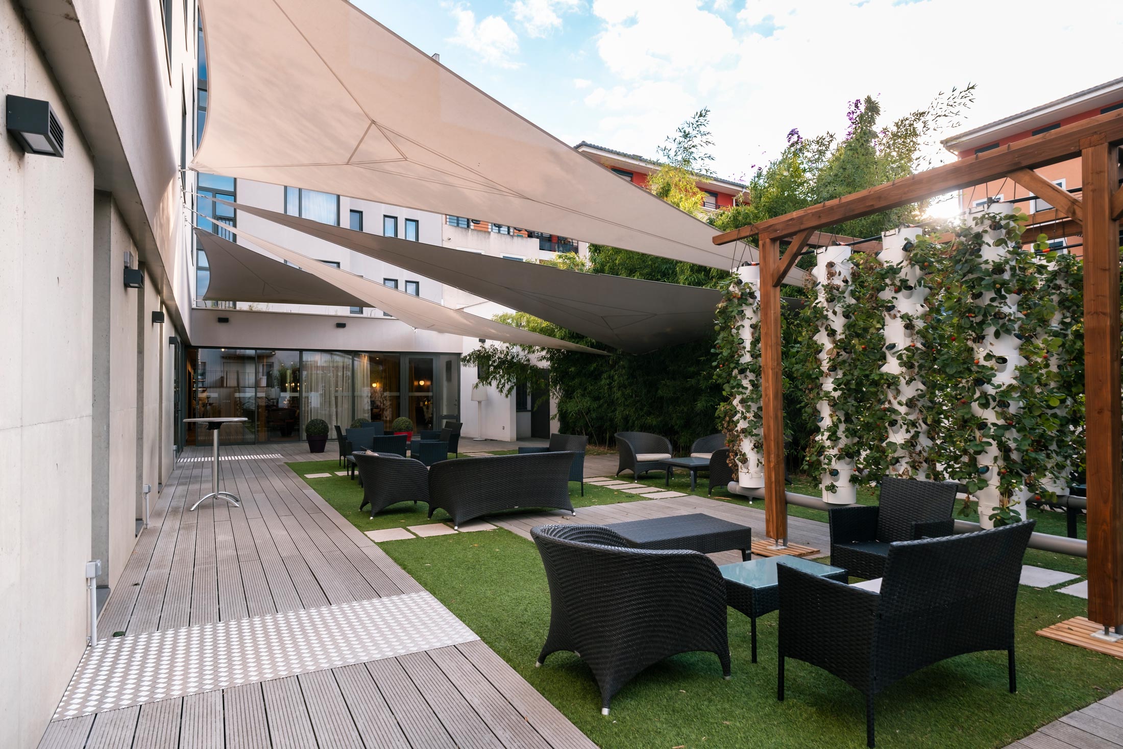 un patio avec des chaises et une table sous un auvent