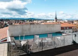 a swimming pool on a balcony overlooking a city