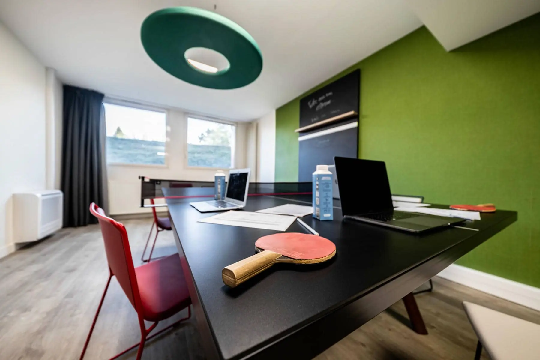 une table noire sur laquelle est posée une raquette de ping-pong