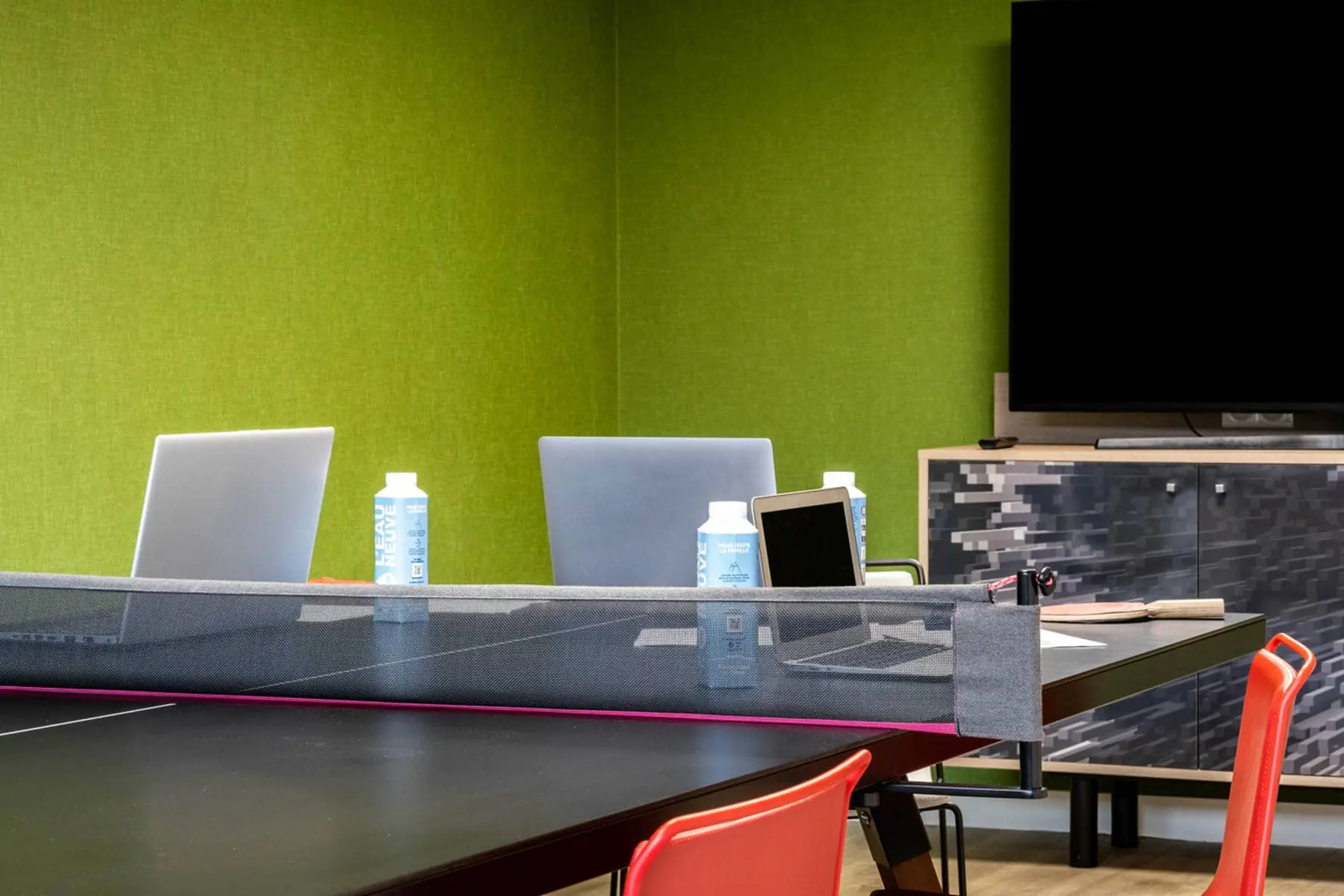 une table avec un filet de ping-pong et un ordinateur portable dessus