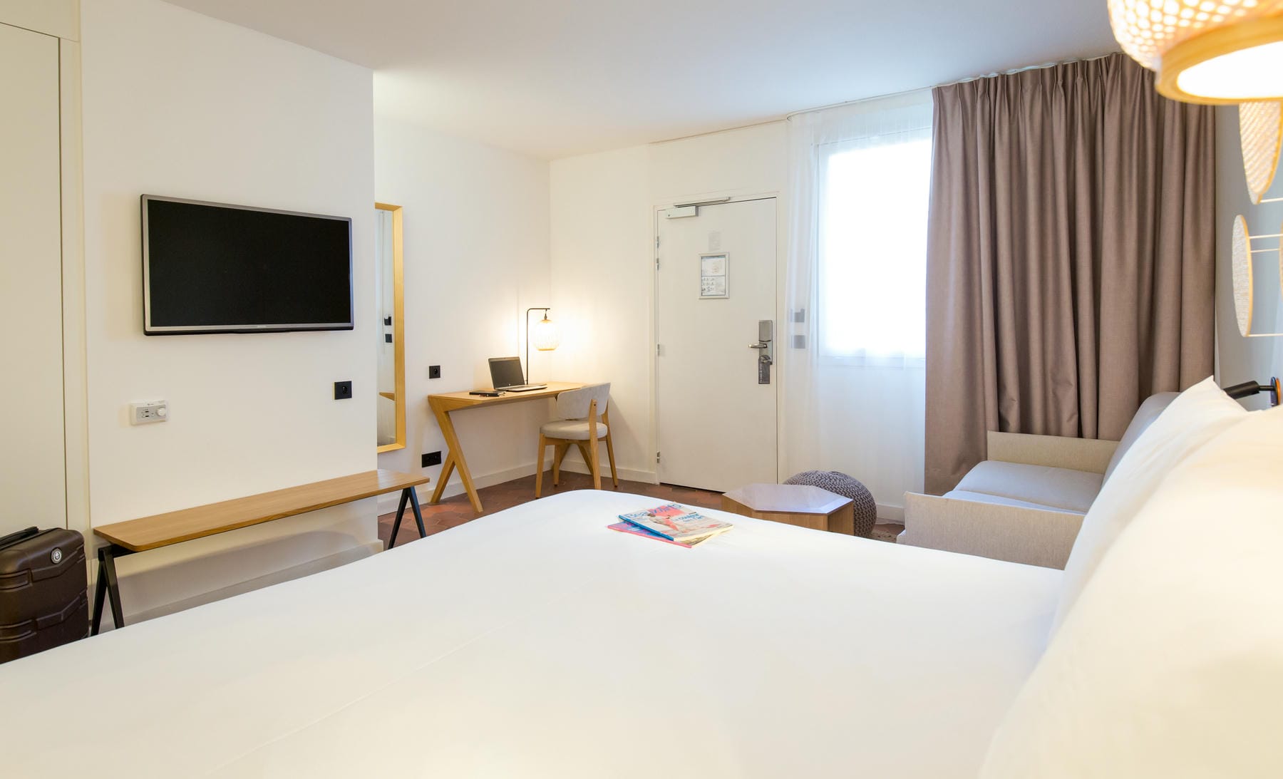 une chambre d'hôtel avec un lit, un bureau et une télévision