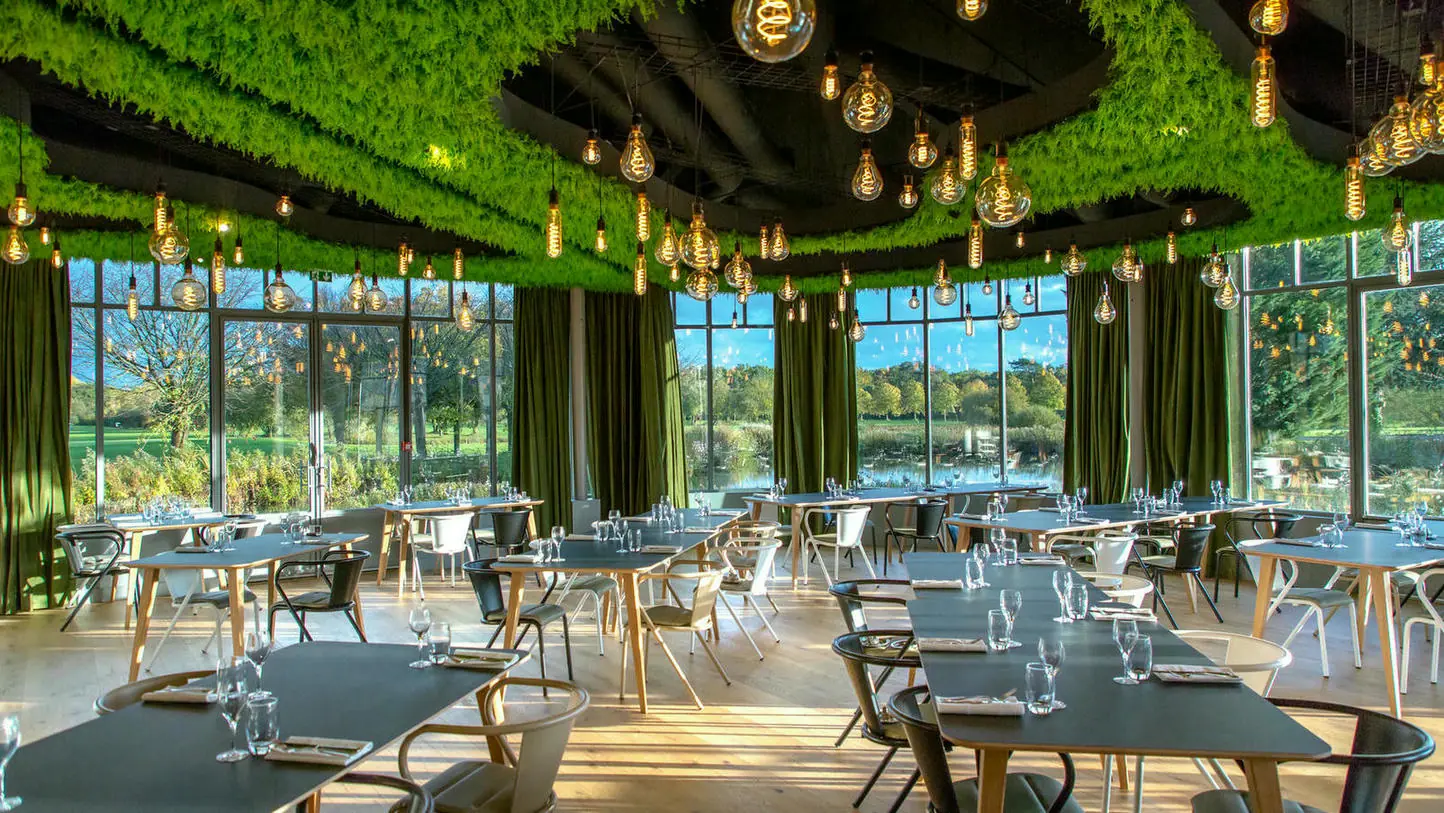 un restaurant avec des tables et des chaises et un plafond vert