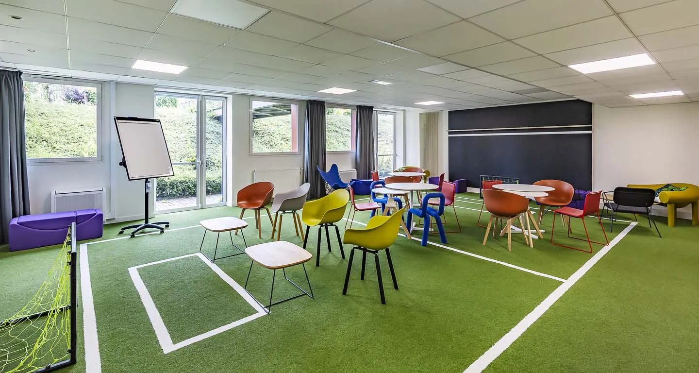 une salle avec des tables et des chaises en forme de terrain de football