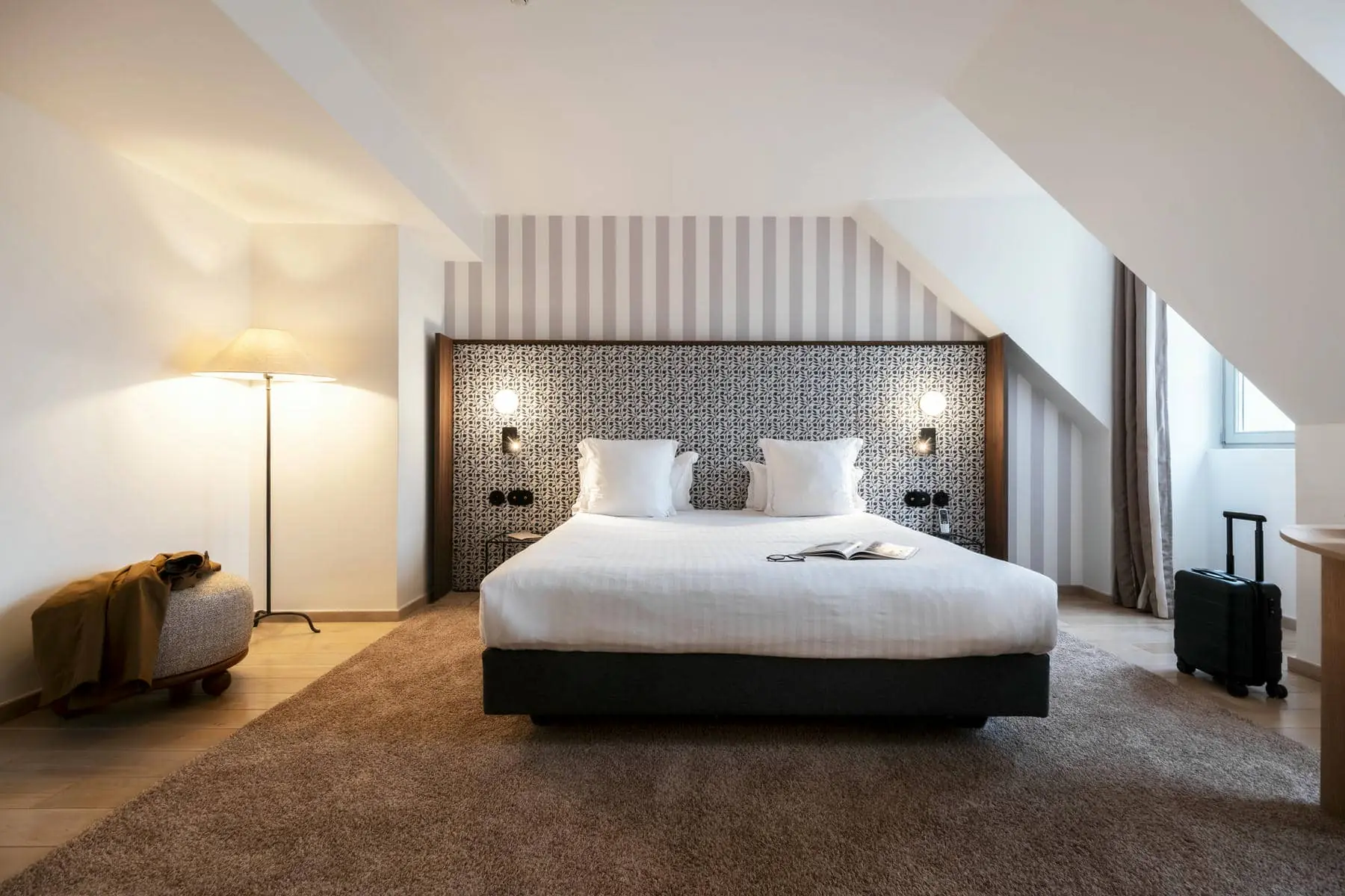 une chambre d'hôtel avec un lit et un livre dessus