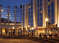 en::Large landmark building in the Boulogne-Billancourt – La Défense area, featuring the Mercure Hotels sign, night view with illuminated façade. fr::Grand bâtiment emblématique du secteur Boulogne-Billancourt – La Défense, avec enseigne Mercure Hotels, vue de nuit et façade éclairée.