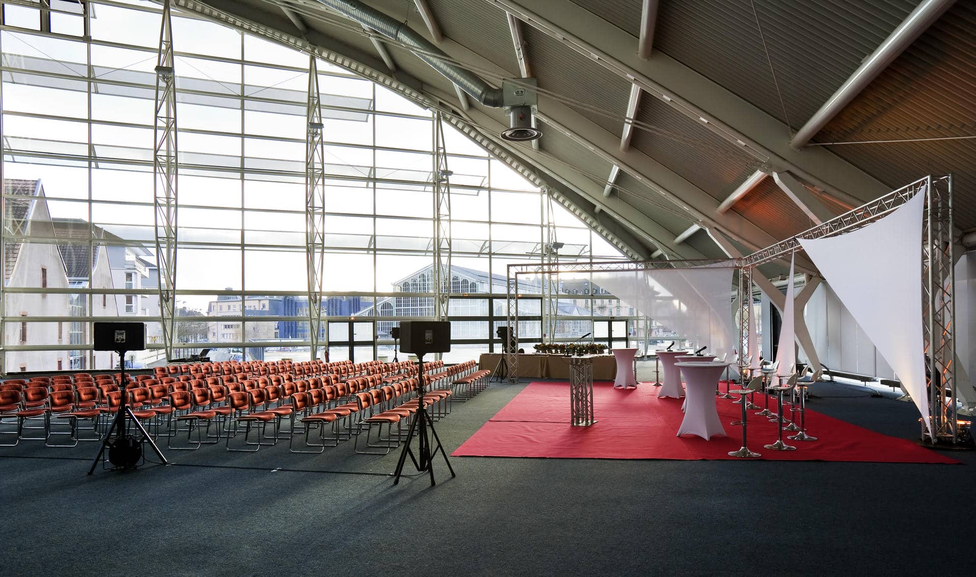 a large room with rows of red chairs and tables