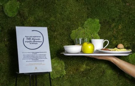 une personne tenant un plateau de nourriture avec un panneau qui dit pour une expérience petit dejeuner engagée authentique et ethique