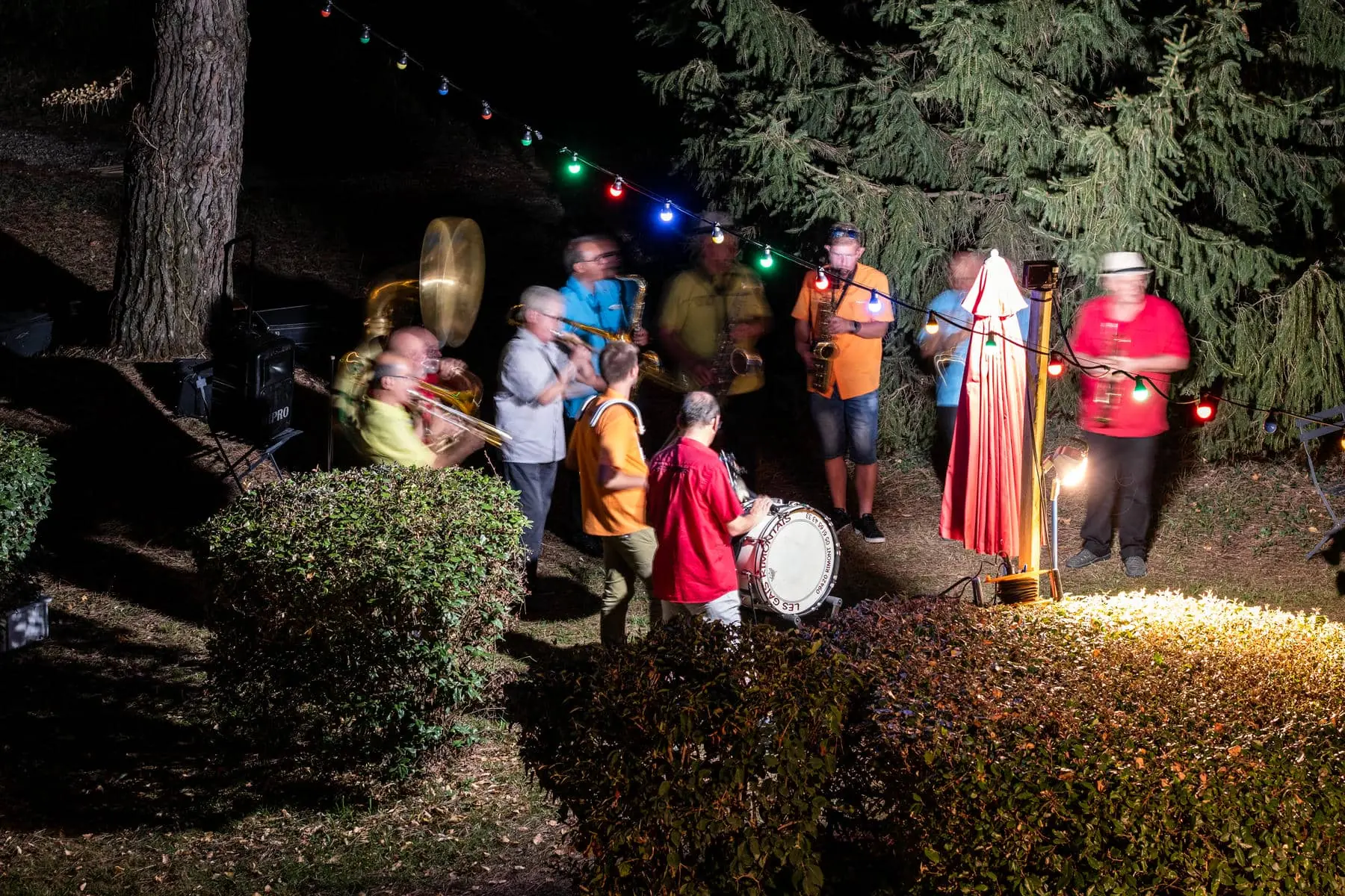 a group of men are playing instruments outside at night
