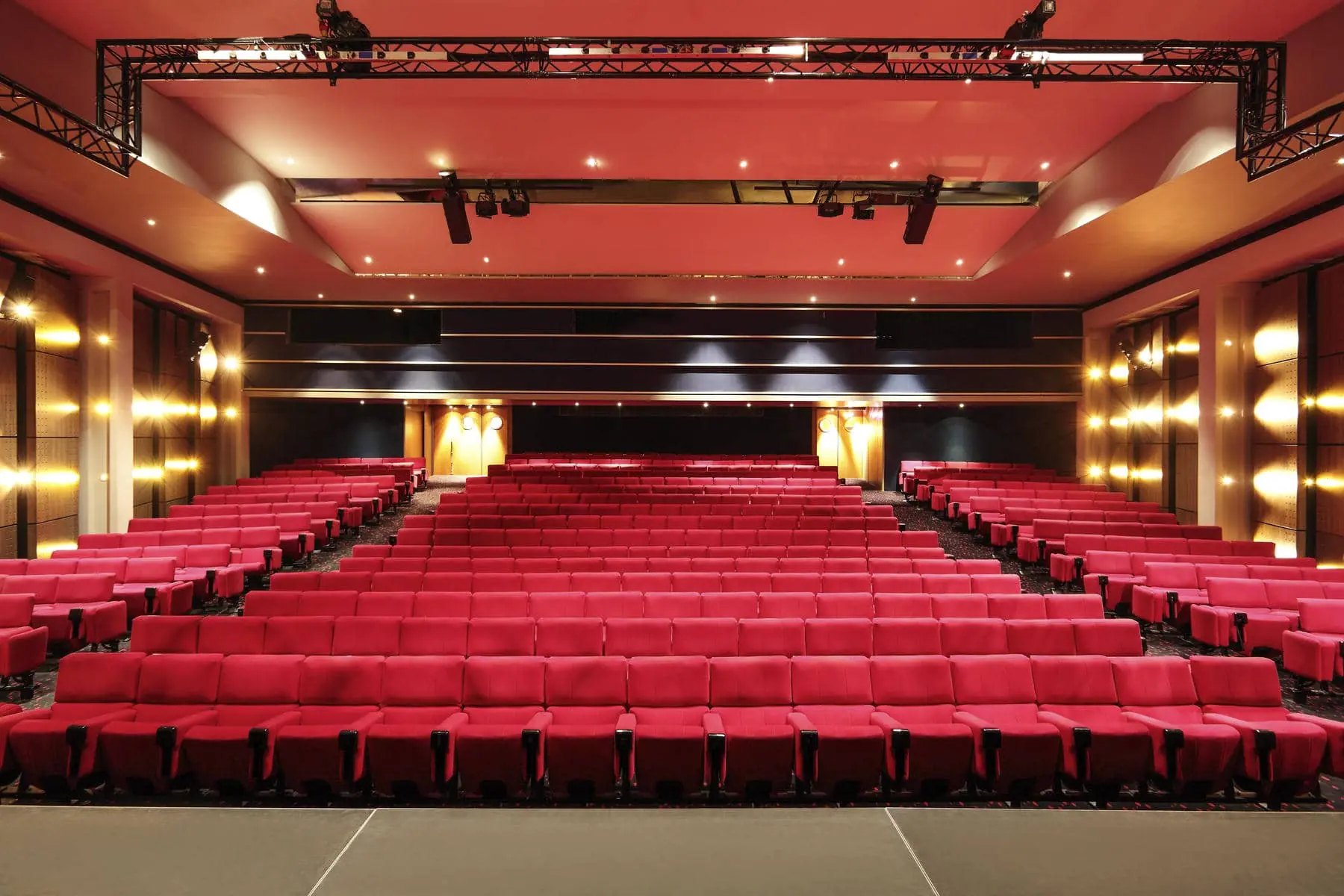 an empty auditorium with red seats and a stage