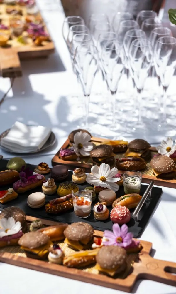un plateau de nourriture orné d'une fleur est posé sur une table à côté de verres de vin