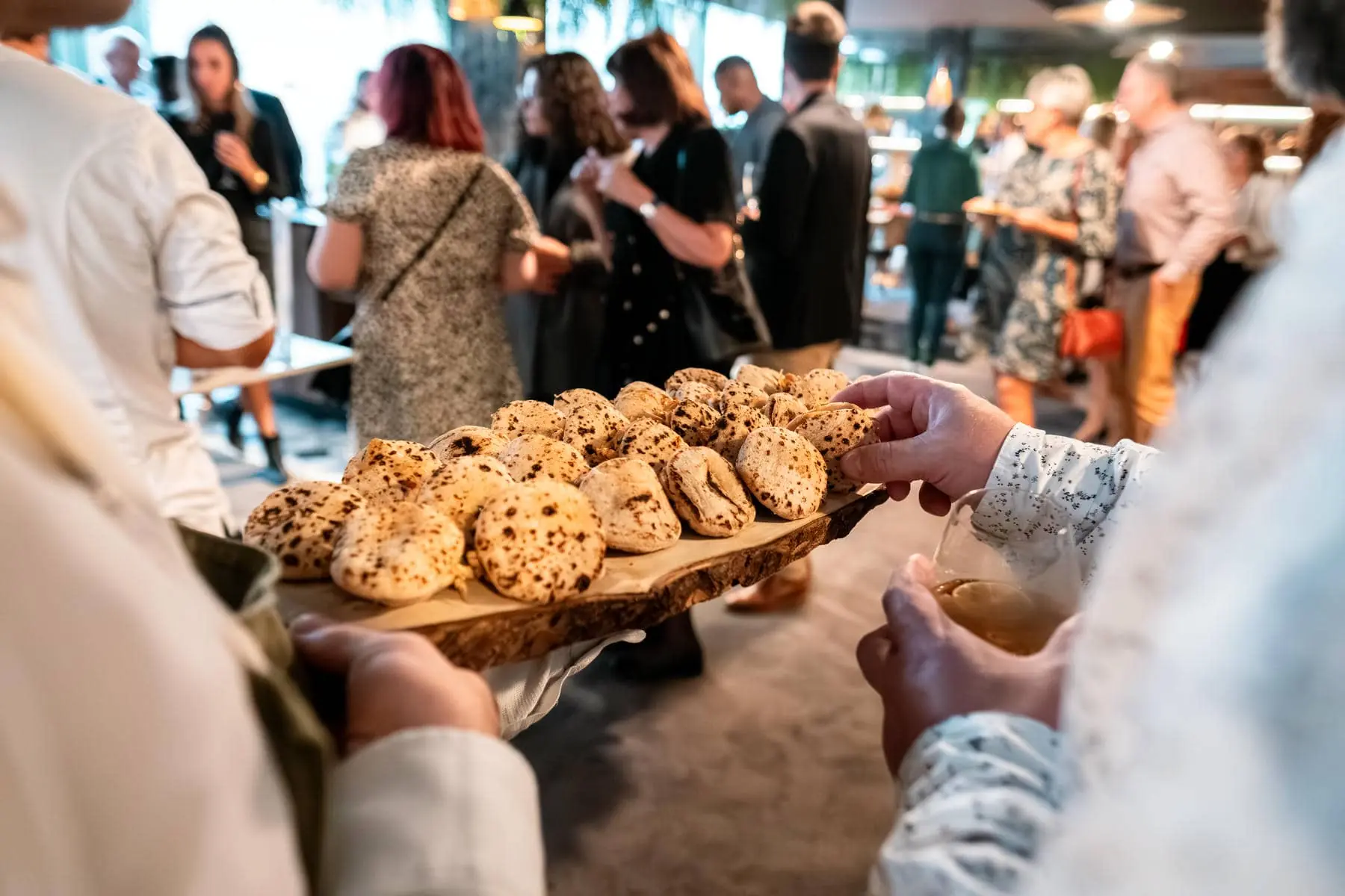 a group of people are gathered around a tray of food