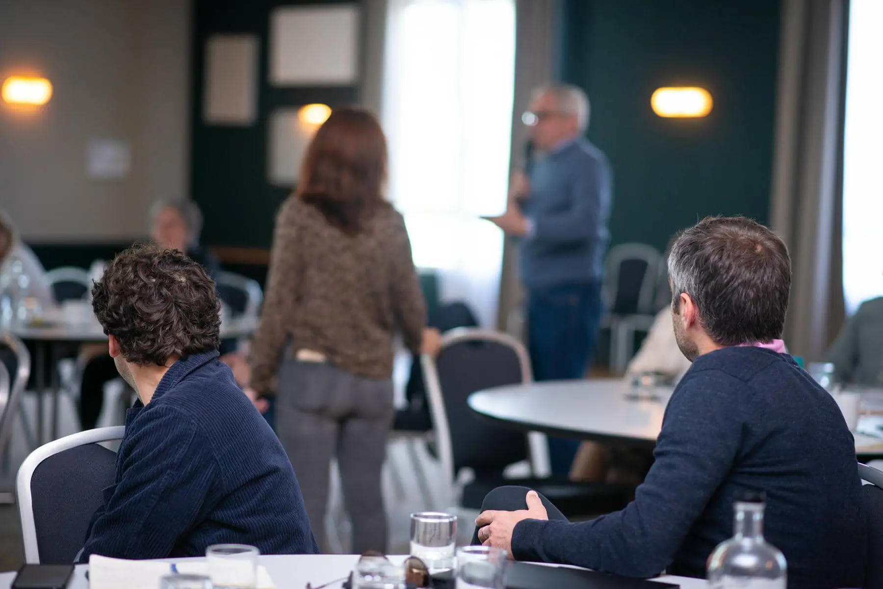 un homme est assis à une table avec une bouteille d'eau devant lui